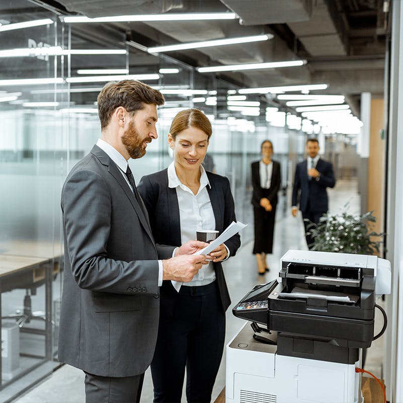 Team members in front of business printer
