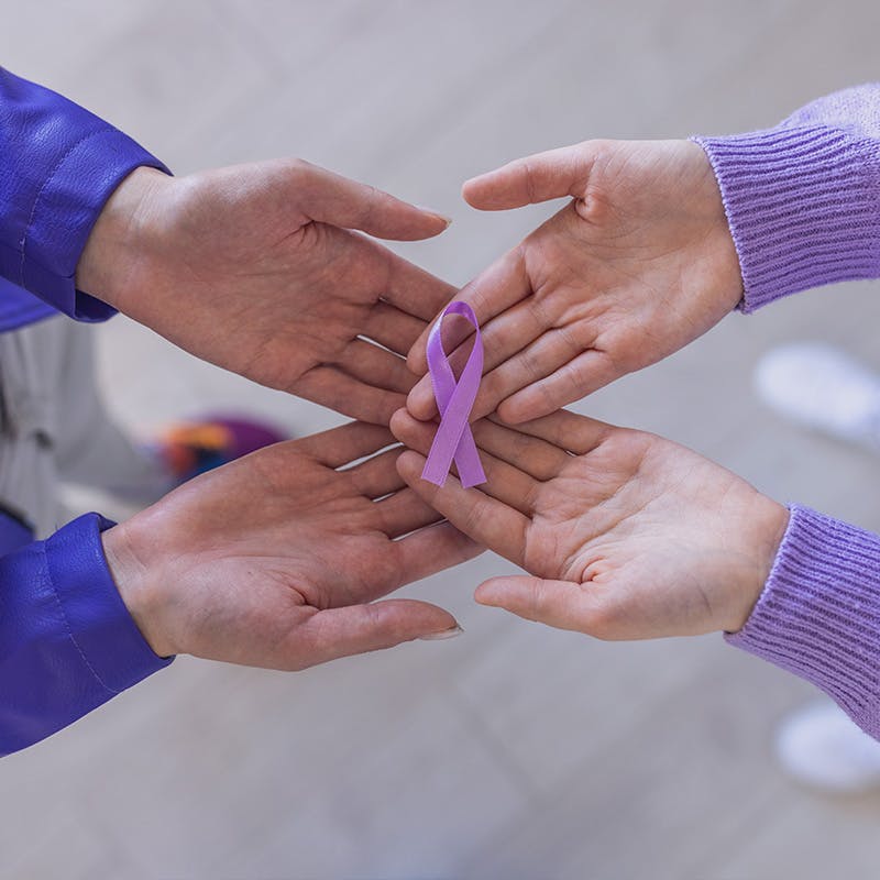Two hands holding an epilepsy awareness ribbon