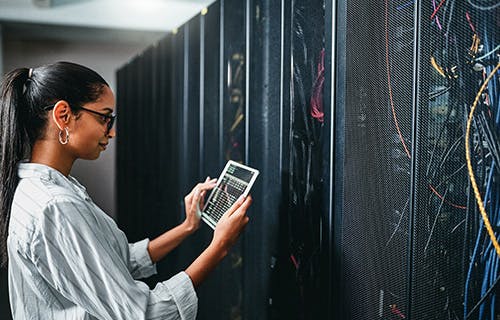 Shot of a young woman using a digital tablet while working in a server room