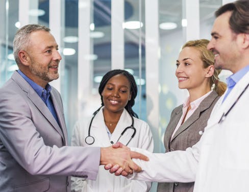 Group meeting of professionals and doctors shaking hands