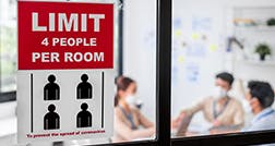 meeting room with sign stating LIMIT 4 PEOPLE PER ROOM