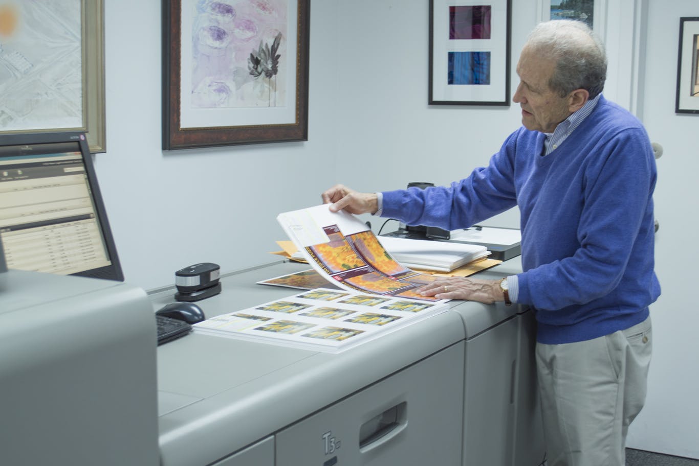 Man looking at printed artwork.