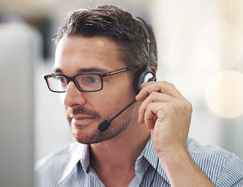 Close up of man with glasses on headset for customer service