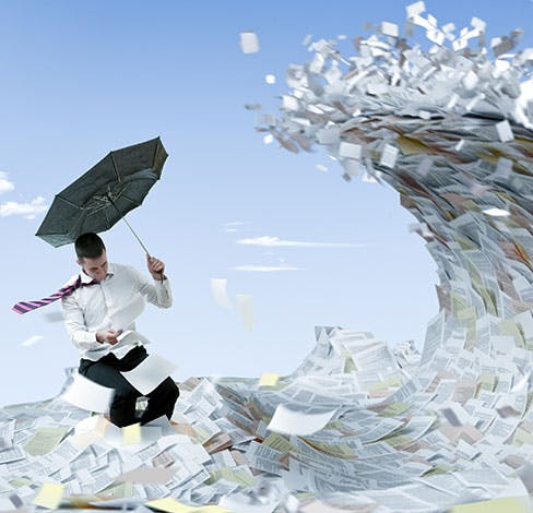 illustration of a wave of paper documents poised to overtake a businessman