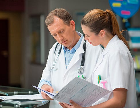 Doctor and nurse looking at patient documents