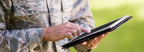 man in army uniform using tablet