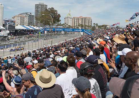 image of a car driving the grand prix track and the stadium full of people
