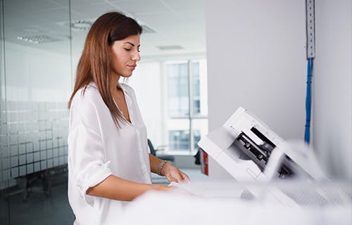 Employee using printer in office setting