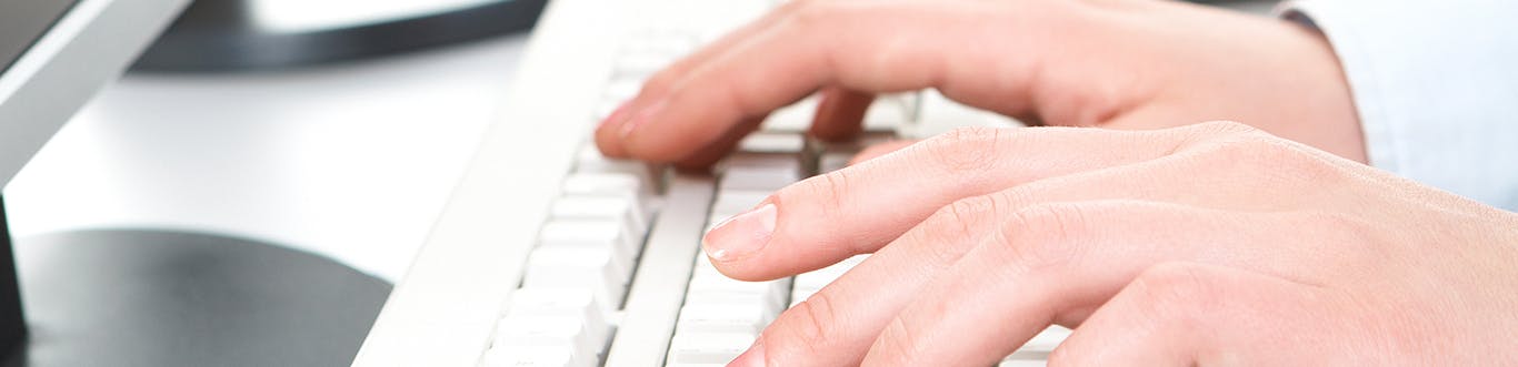 Photo of a close up of hands typing on keyboard