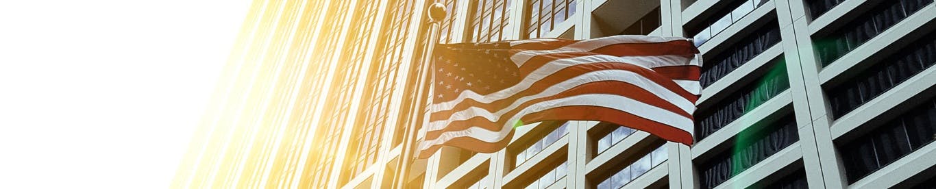 outside view of large office building with american flag in foreground