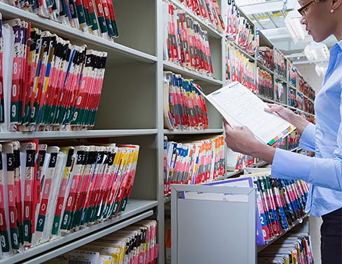 Professional woman sorting files in a file rack