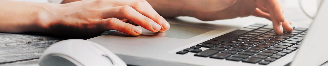 Woman typing on a laptop keyboard.