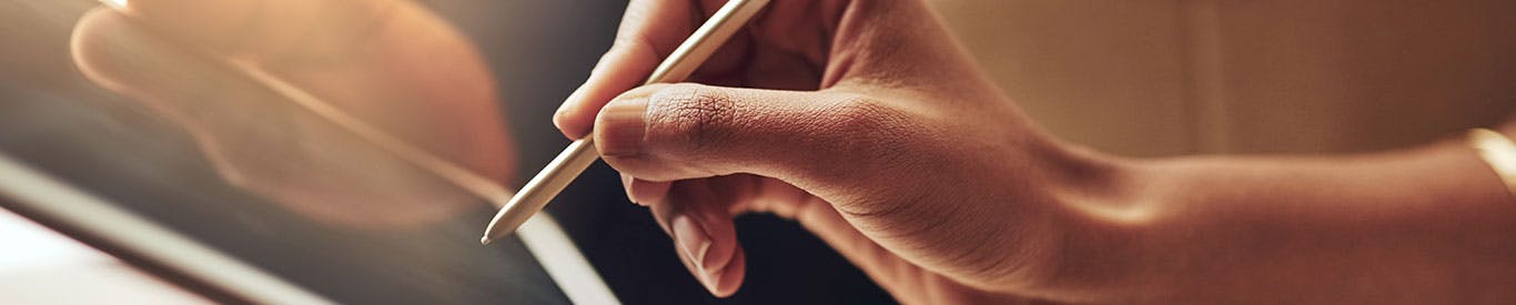 hand using a stylus to sign a tablet for receiving a package