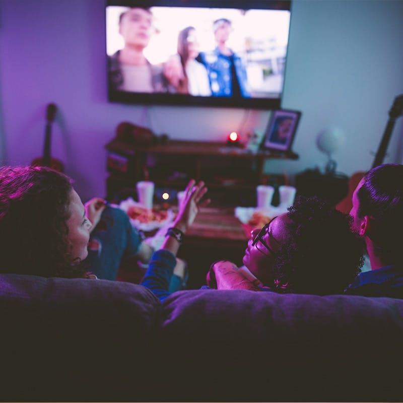 Group of people watching a movie streamed on the television