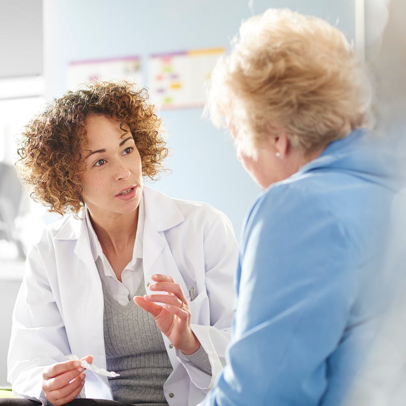 older woman and doctor talking in room