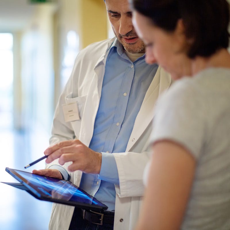 Doctor showinga patient something on a digital tablet