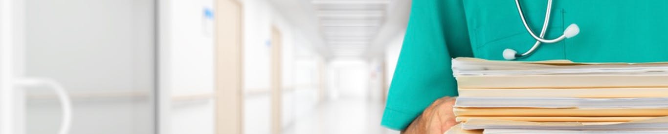 Nurse holding stack of documents