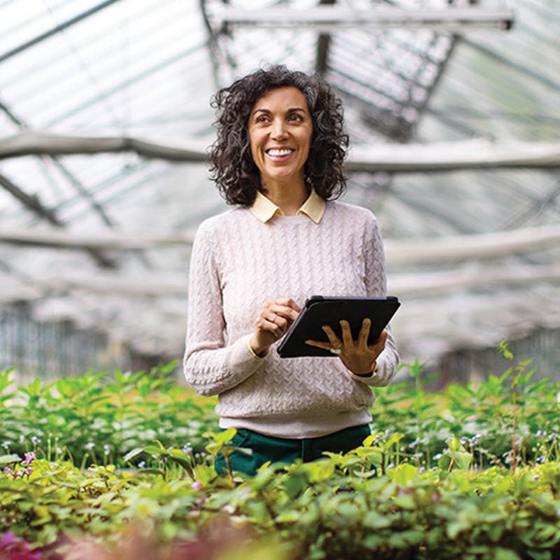 Woman using tablet in greenhouse - Battlefield Farms