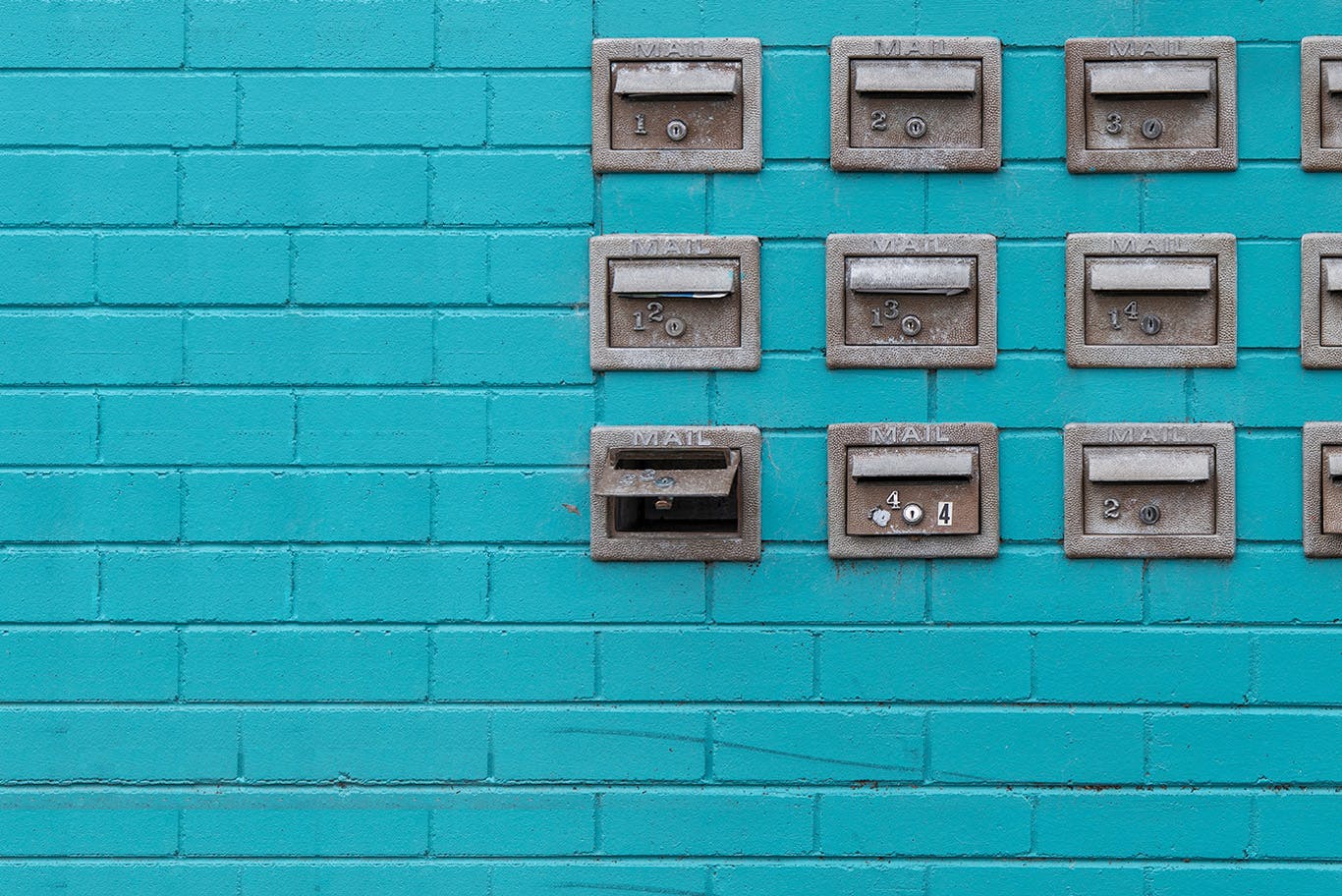 Mail boxes on teal brick wall