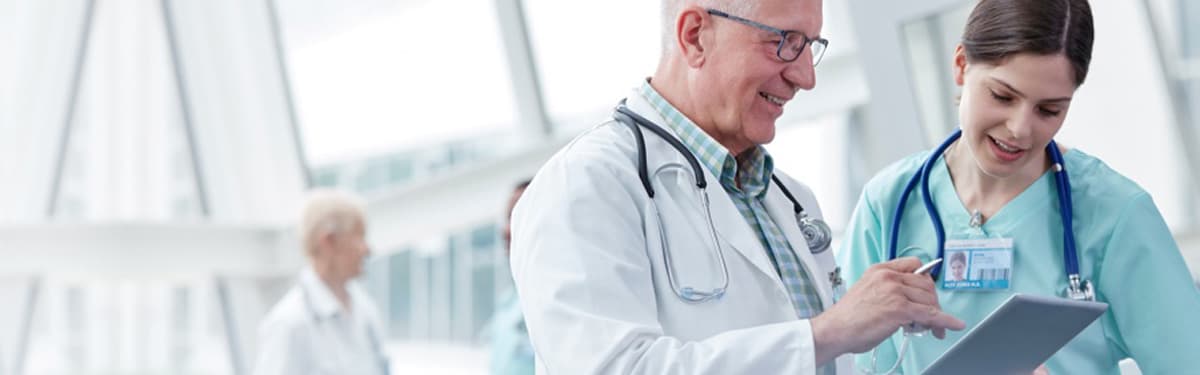 Male and woman doctors working together with tablet