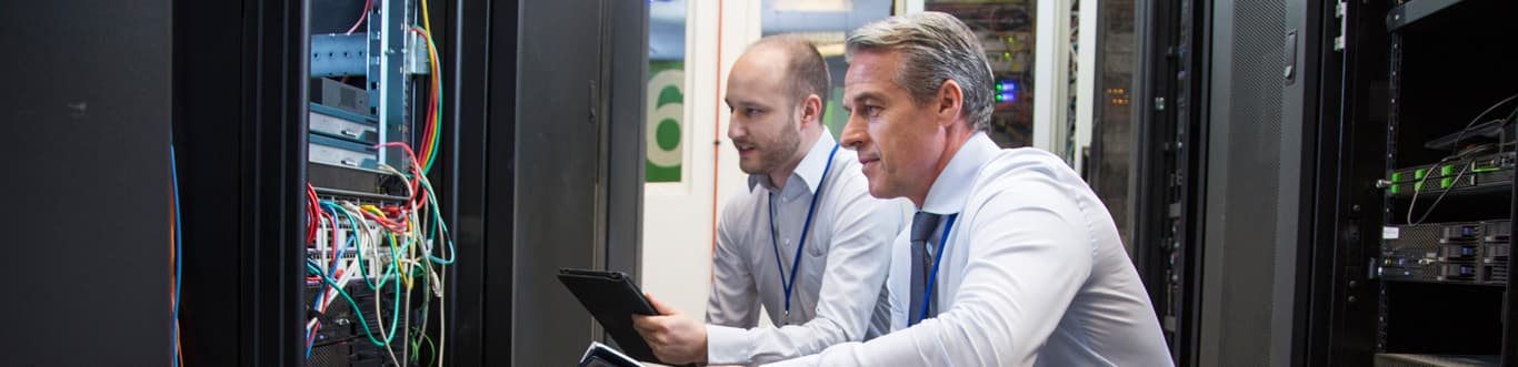 Two professionals working on computer server room