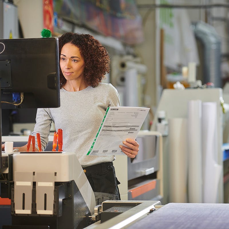 Woman working on a comercial industrial printer