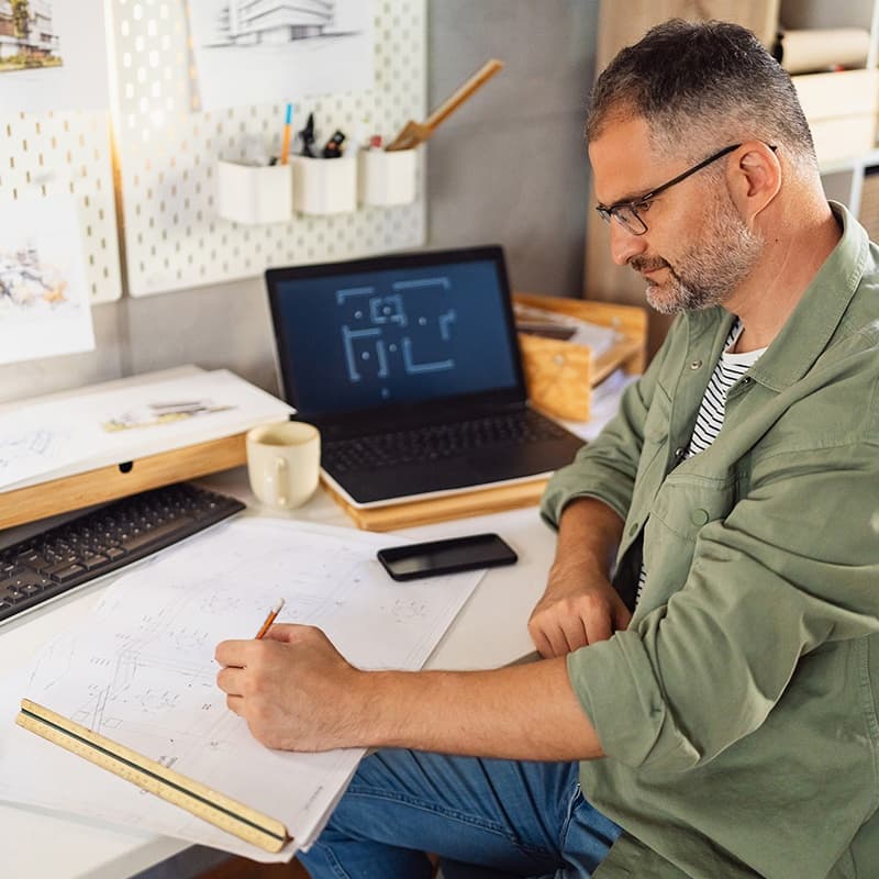 architect working on print and digital copy on his screen