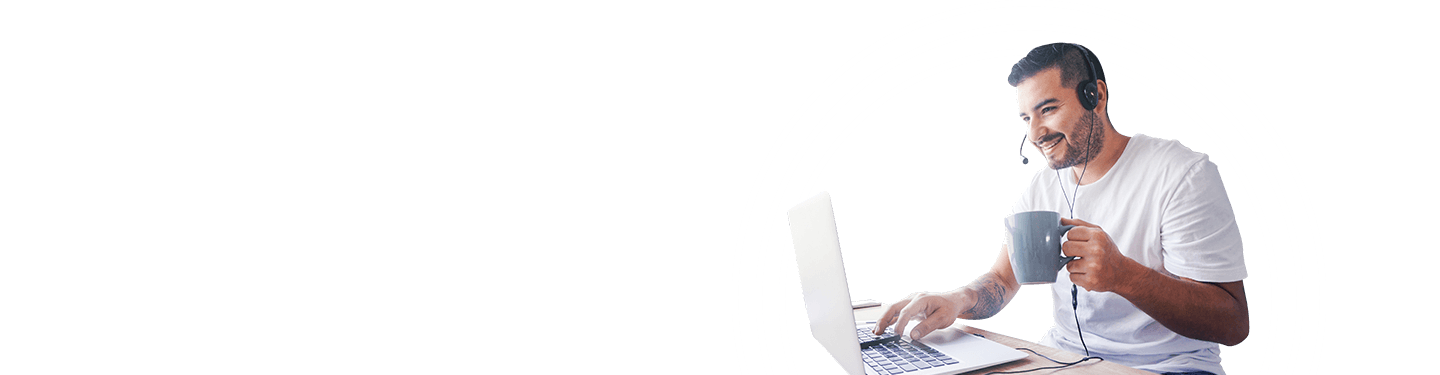 Man working on his laptop with headset and holding a coffee mug