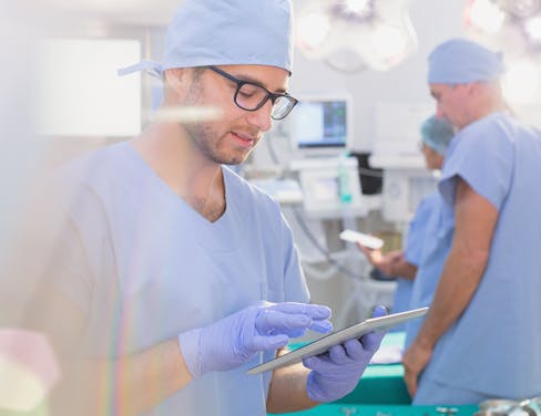 Surgeon using digital tablet in operating room