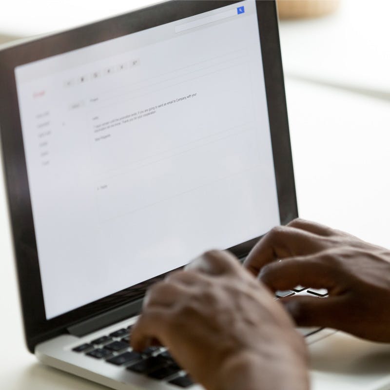 man typing document on laptop