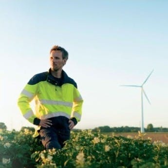 Man standing in a field of wind turbines