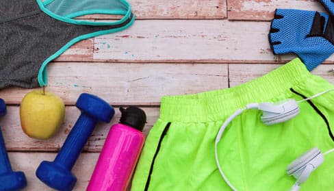 althetic clothing and equipment layed out on a wooden floor or table