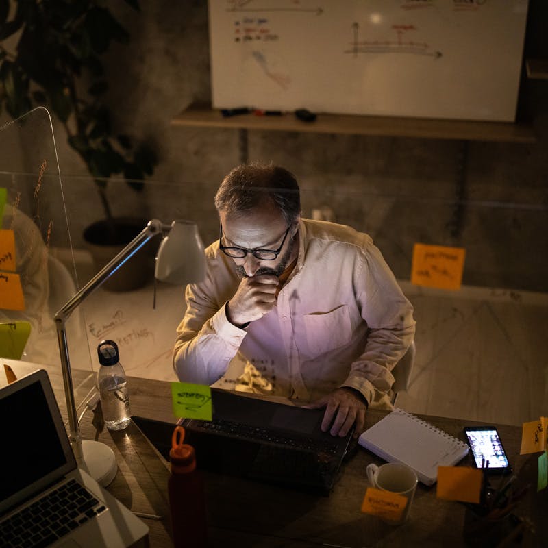 man on computer surrounded by post-it notes