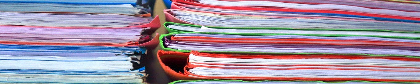 close up of colorful stacked folders with papers inside