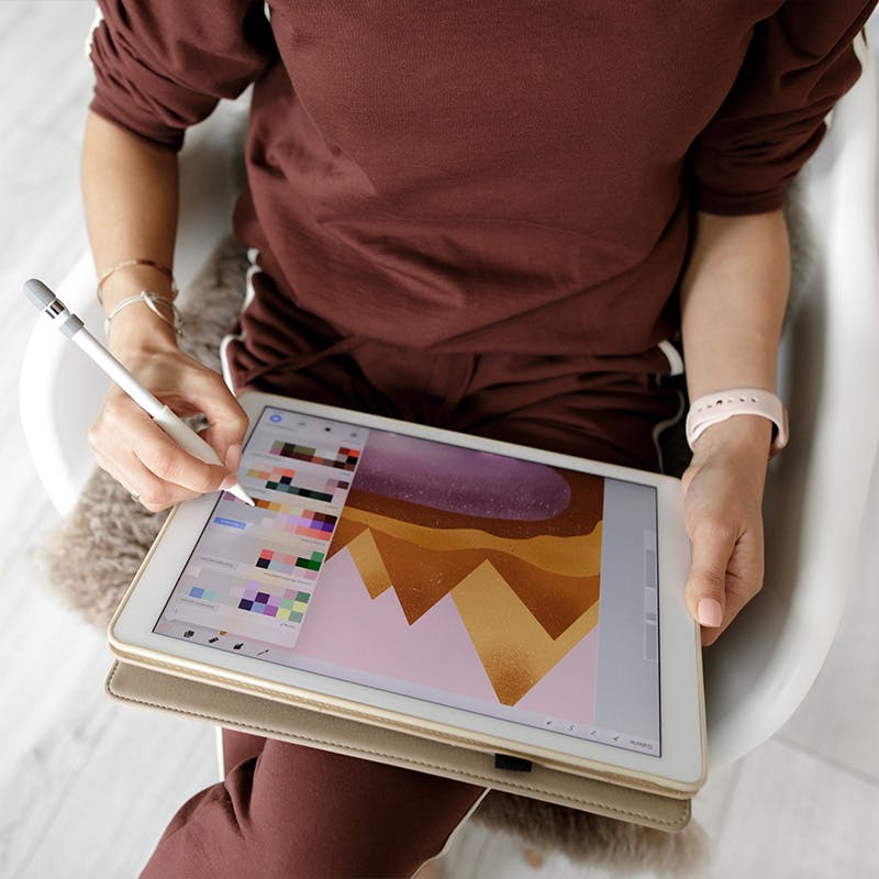 Person working on a graphic piece with a tablet and stylus