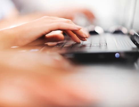 Ricoh close-up of a woman typing on laptop