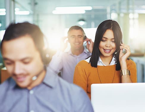 Three customer representatives talking on their headsets.