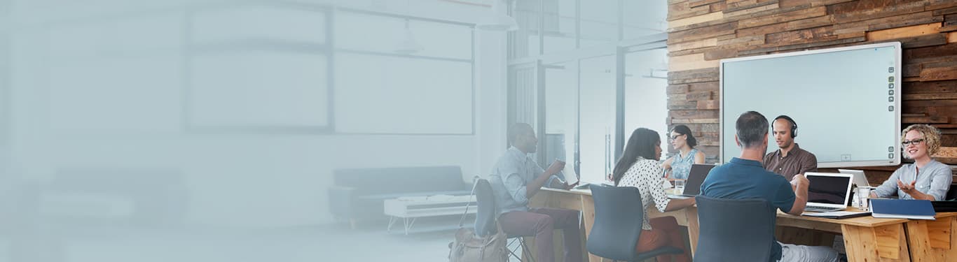 Open work table with an interactive whiteboard behind professionals.