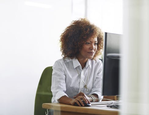 African american female office clerk using desktop computer.