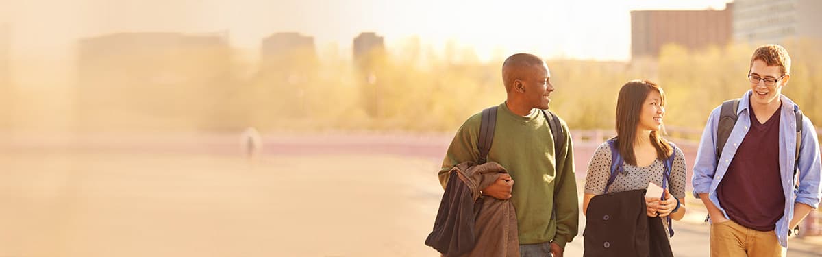 Photo of 3 students walking and talking.