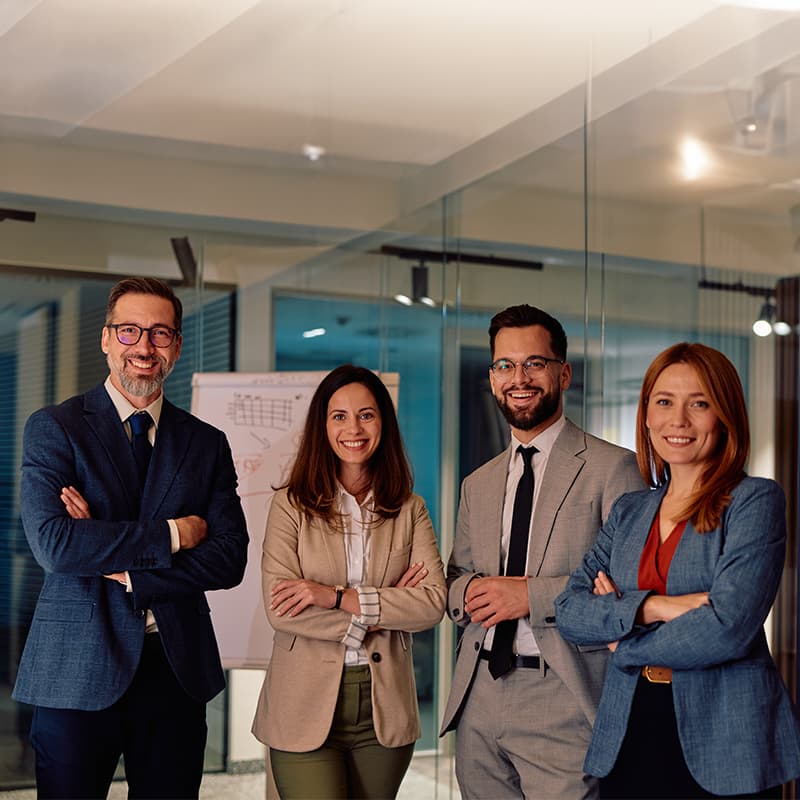 Group of professionals standing together in an office environment, representing corporate careers, cross-functional collaboration, and business leadership.