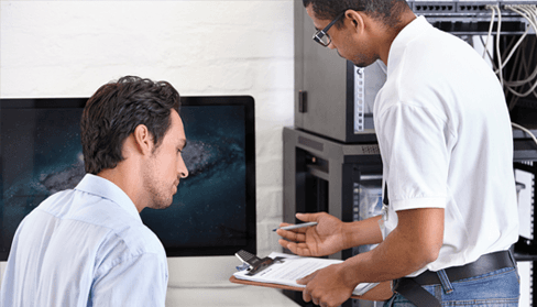 Two professionals working on a computer.