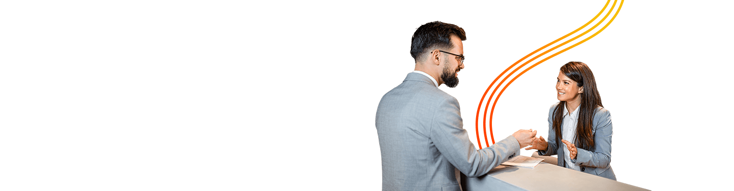 Woman chatting with a man behind a desk, demonstrating experienced professionals with proven service standards in hospitality & reception services.