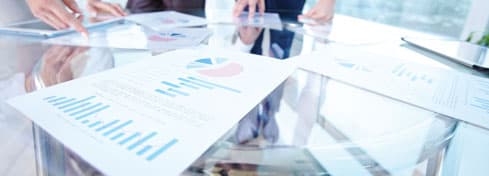 Closeup photo of hands touching documents with graphs.