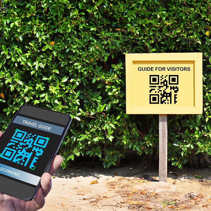 Signage of QR code and a person scanning with mobile phone