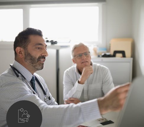 Male doctor with patient pointing on tablet