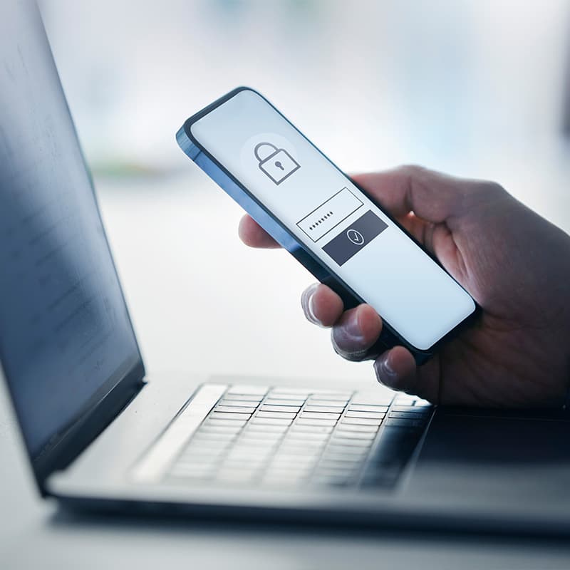Man holding smart phone with data security on display at office