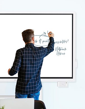 man writing on interactive flat panel display