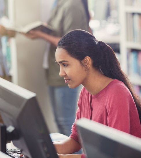 college student in library looking at computer