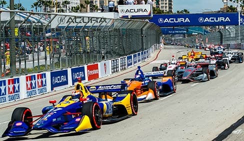 images of cars going around the corner of the race track